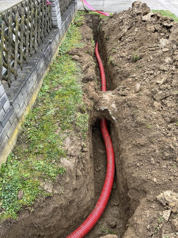 Izkopan jarek z rdečo zaščitno cevjo za električne kable