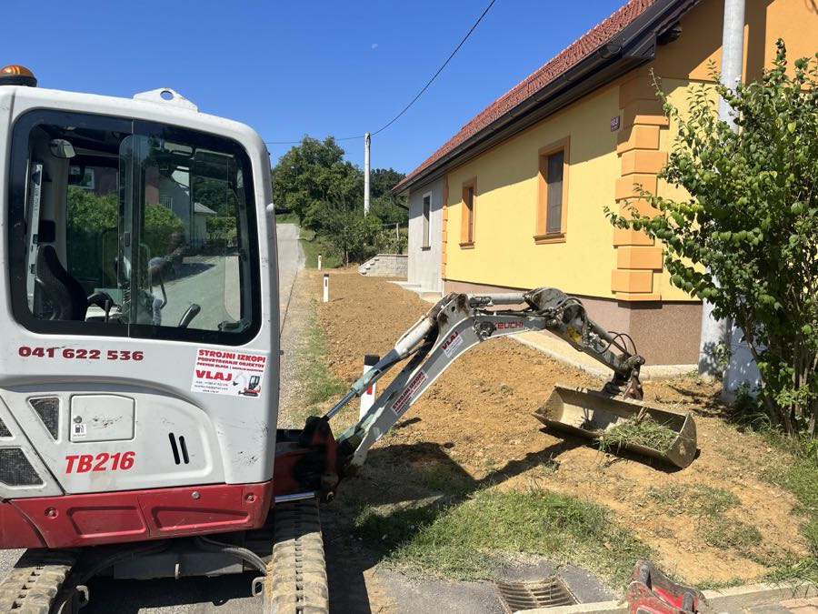 Bager pri urejanju okolice hiše in izravnavi terena
